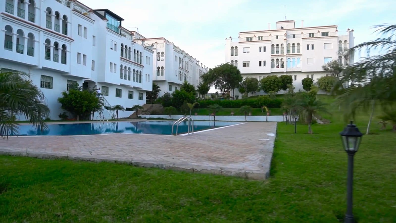La piscine bordée par les bâtiments de la résidence